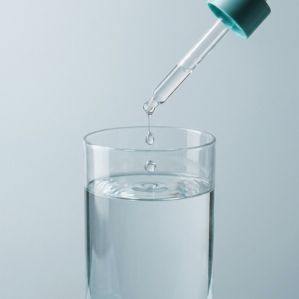 Adding the drops to a glass of water